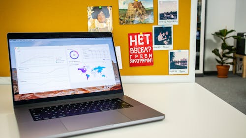 Laptop on a desk in an office with Social Media Analytics Stats on the screen