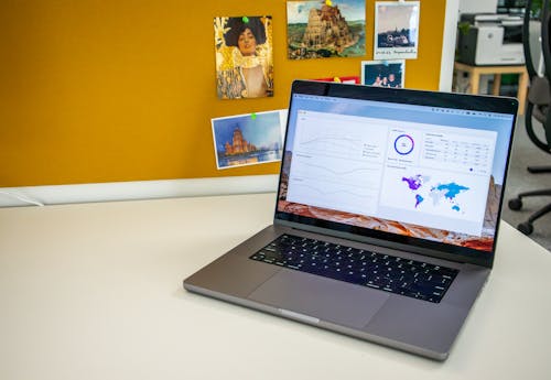 Laptop on a desk in an office with Social Media Analytics Stats on the screen