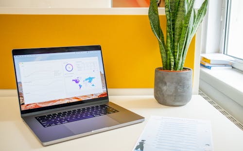 Laptop on a desk in an office with Social Media Analytics Stats on the screen