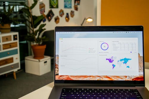 Laptop on a desk in an office with Social Media Analytics Stats on the screen