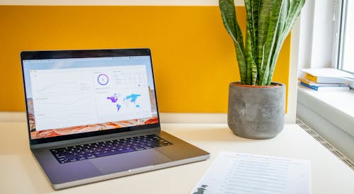 Laptop on a desk in an office with Social Media Analytics Stats on the screen