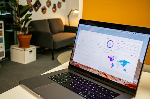 Laptop on a desk in an office with Social Media Analytics Stats on the screen