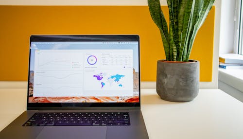 Laptop on a desk in an office with Social Media Analytics Stats on the screen