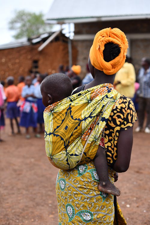 A woman with a baby in a yellow headscarf