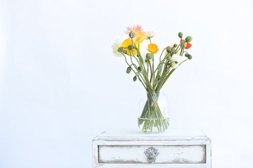 A vase filled with flowers on a white table