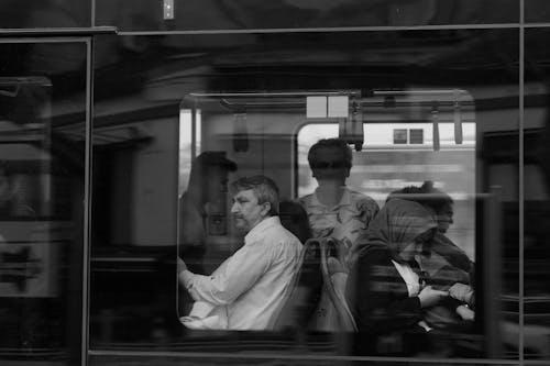 A black and white photo of people on a train