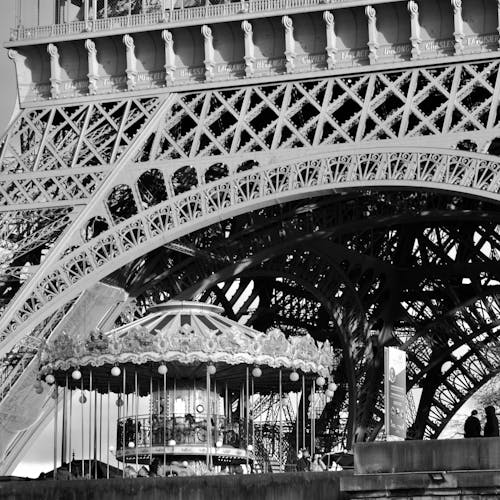 Black and white photo of the eiffel tower with a carousel