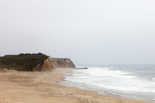 A beach with a cliff and a sandy shore