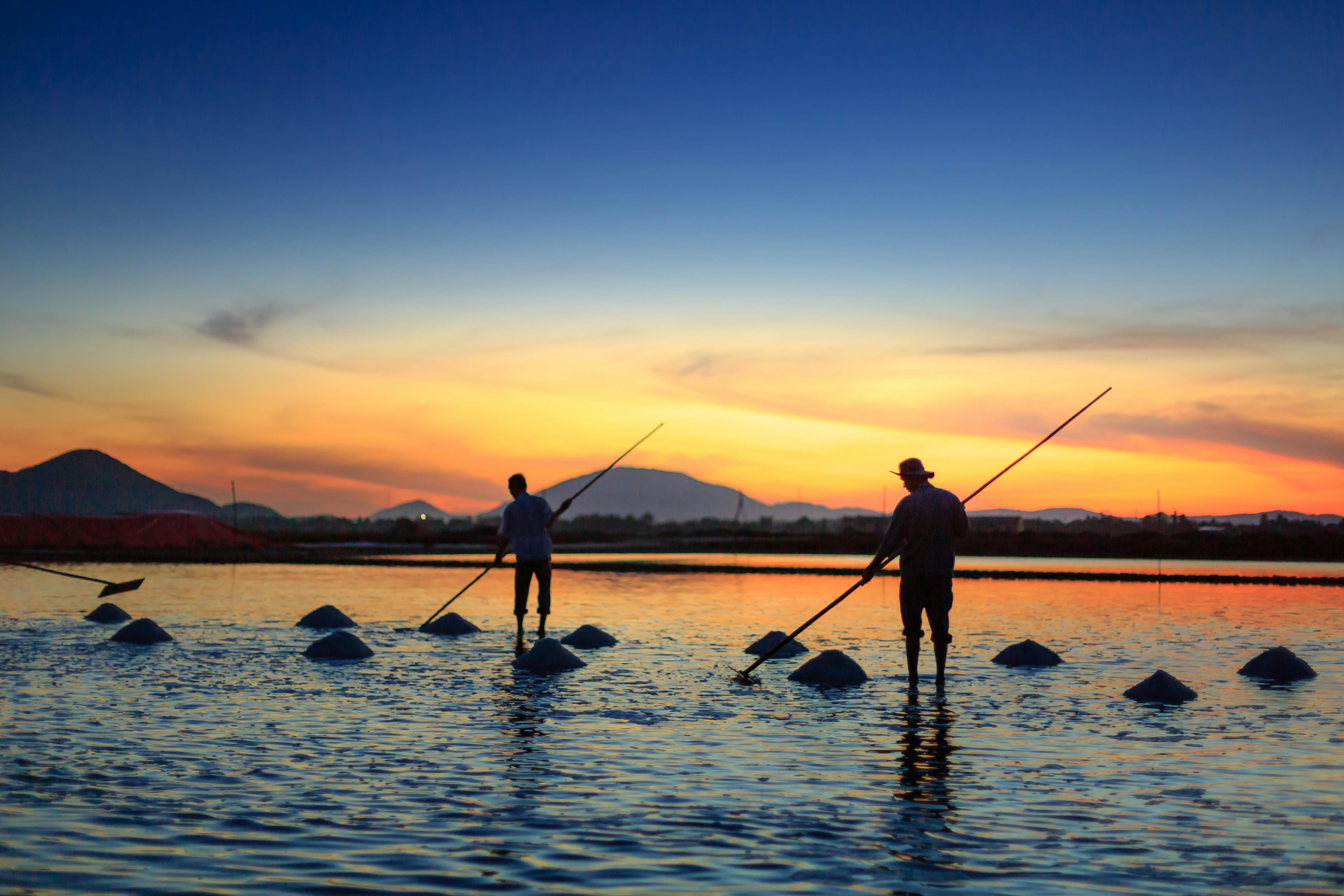 Silhouette of Two Men Fishing on Body of Water · Free Stock Photo