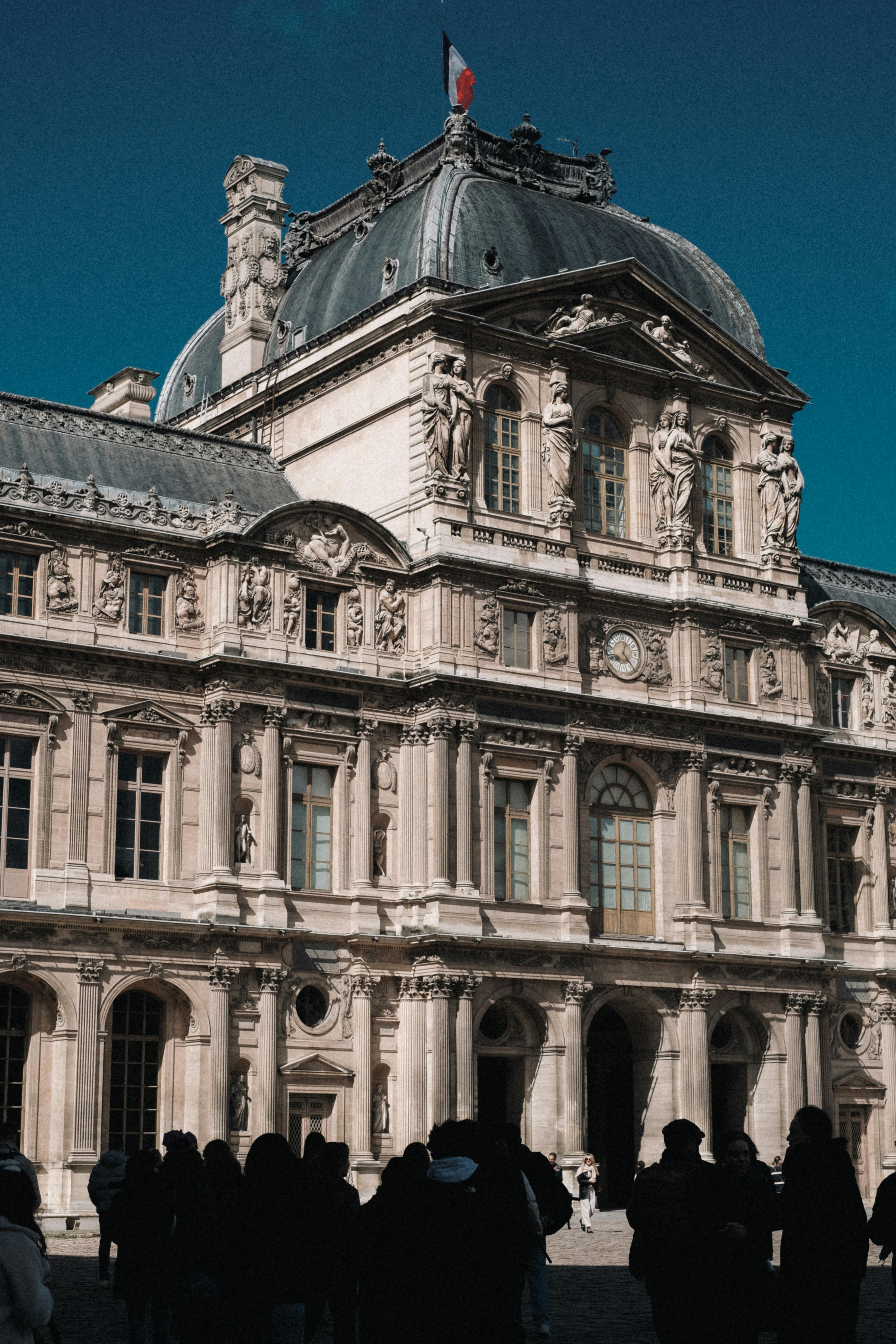 Stunning baroque facade of the Louvre Museum in Paris, popular tourist attraction.