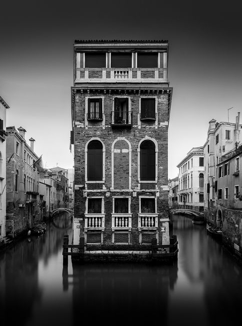 Black and white photo of a Venetian canal with historic architecture in Venice, Italy.