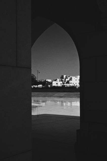 A striking black and white view through an archway capturing Muscat's architecture.