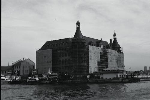 A black and white photo of a building on the water