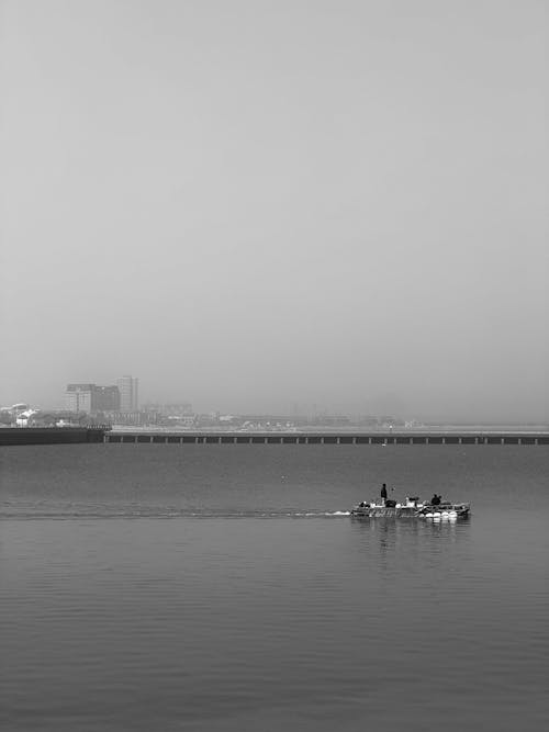 A boat in the water with a foggy sky