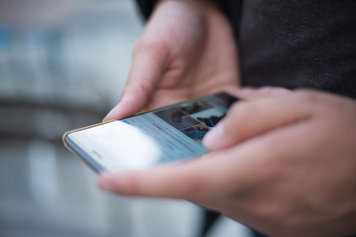 Elde tutulan akıllı telefon ekranında bahis uygulaması açık