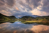 黄昏时分，宁静的湖泊倒映着山脉，在戏剧性的天空下，捕捉到大自然的静谧