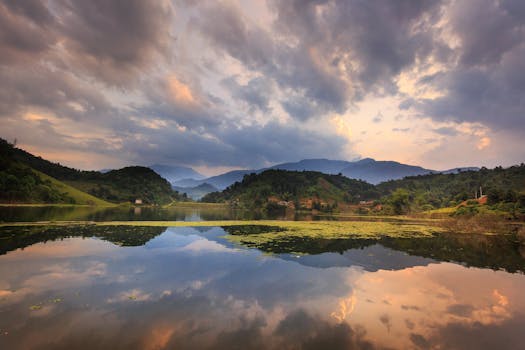黄昏时分，宁静的湖泊倒映着山脉，在戏剧性的天空下，捕捉到大自然的静谧