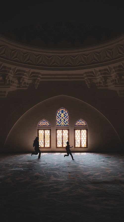 Free Silhouettes running inside the grand mosque in İstanbul with scenic windows and arches. Stock Photo