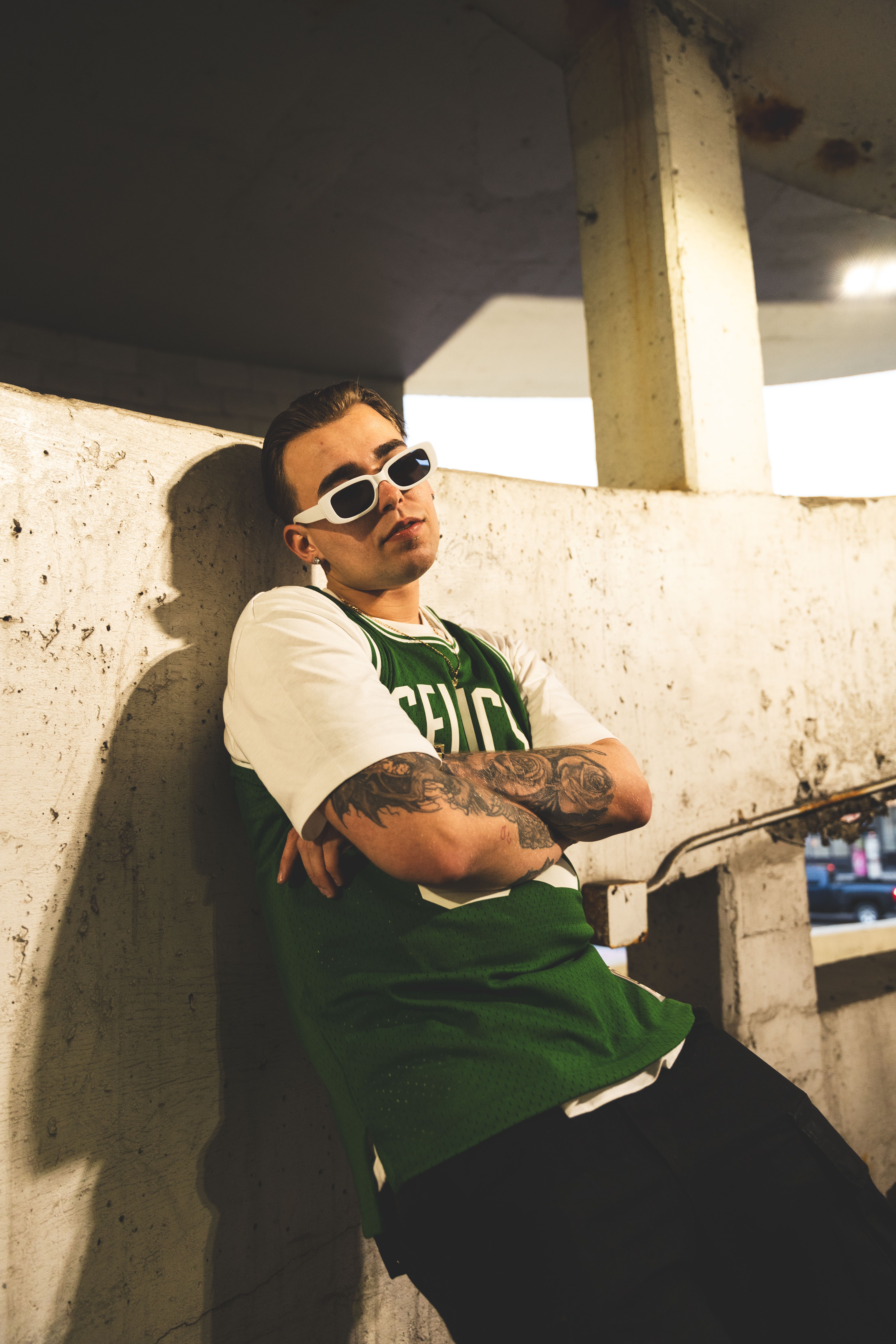 A man in sunglasses leaning against a wall · Free Stock Photo