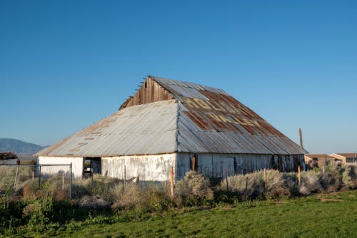 An old barn sits in the middle of a field