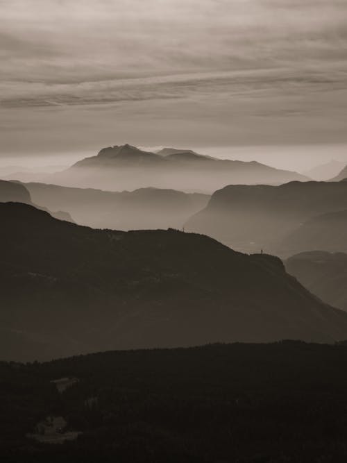A black and white photo of mountains and fog