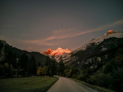 Free A road leading to a mountain range at sunset Stock Photo