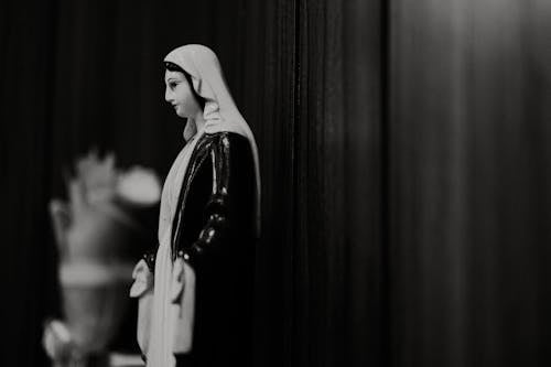 A black and white photo of a statue of mary