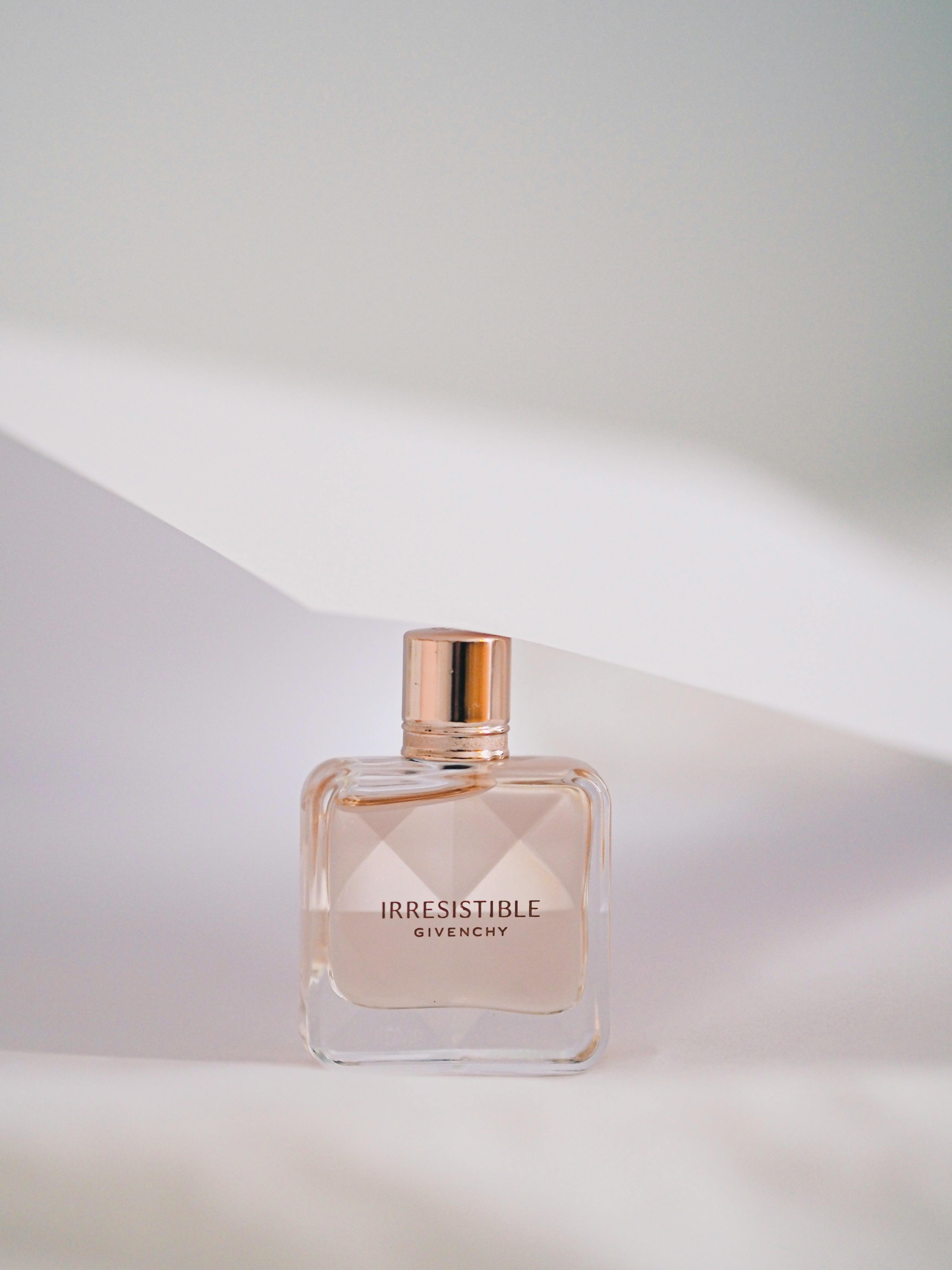 A stylish Givenchy perfume bottle captured with a minimalist white backdrop, ideal for luxury and fashion themes.