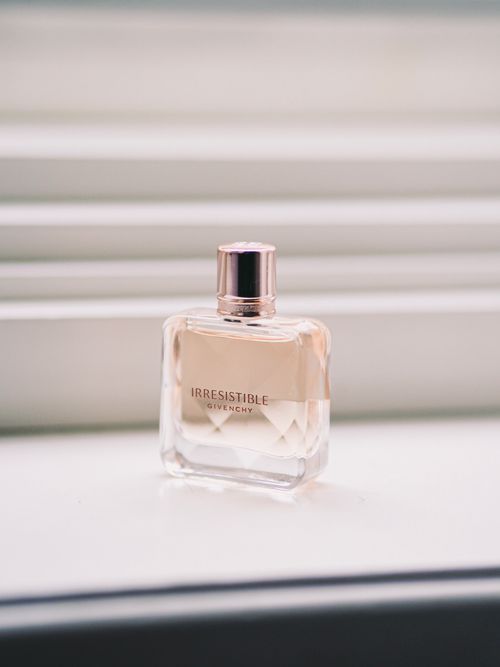 Free Chic Givenchy perfume bottle in soft natural light on a white surface, Paris ambiance. Stock Photo