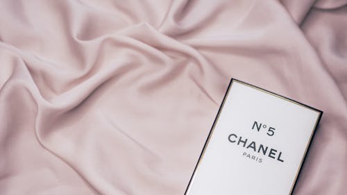 Free Chanel no 5 perfume on a pink silk sheet Stock Photo