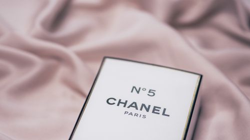 Free Elegant Chanel No. 5 perfume box placed on a delicate fabric surface. Stock Photo