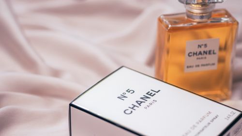 Free Chanel No.5 perfume bottle with box on soft fabric background in Paris. Stock Photo