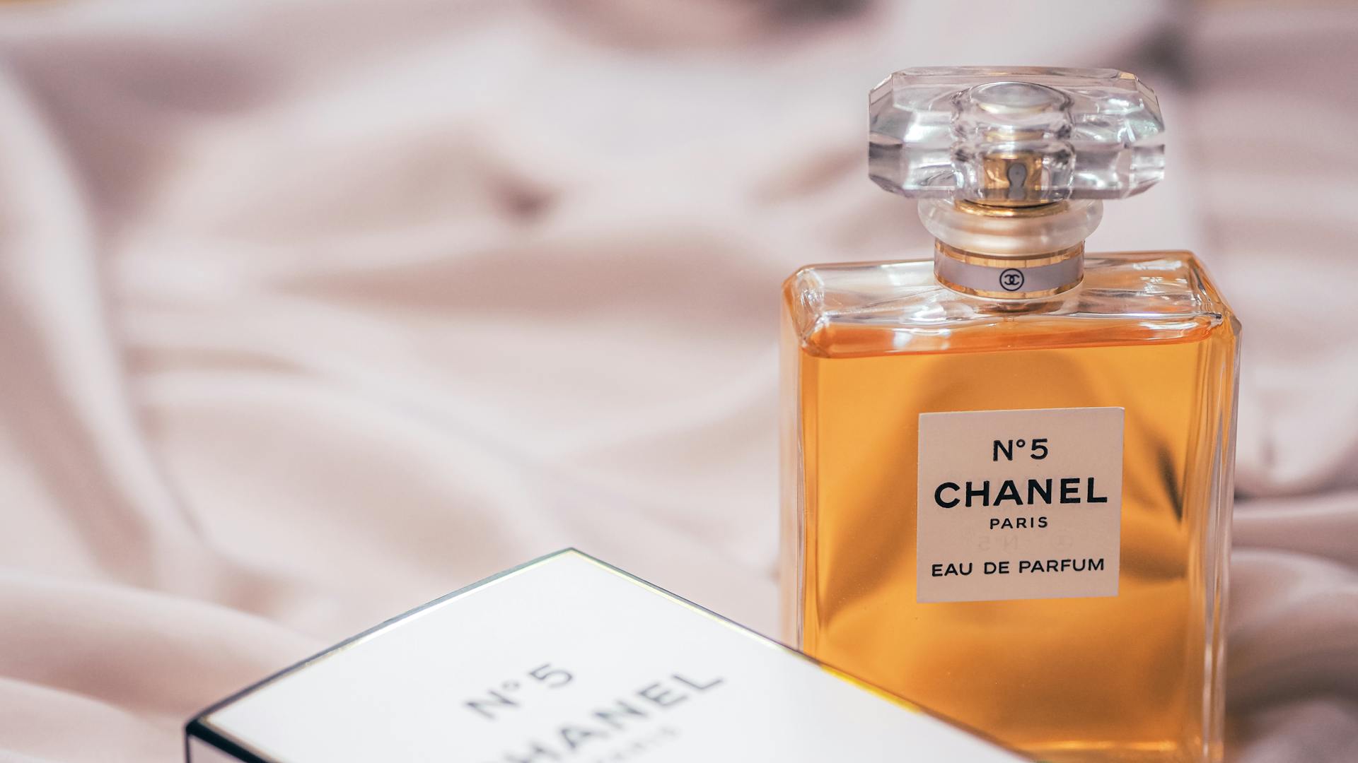 Chanel No. 5 perfume bottle elegantly displayed with packaging in a soft, luxurious setting.