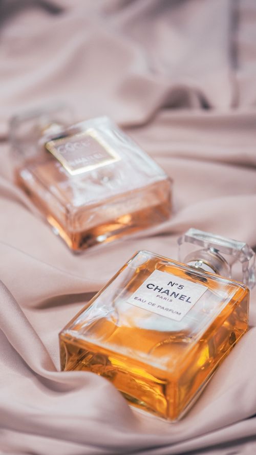 Free Close-up of Chanel perfumes on silky fabric, showcasing elegance and luxury in a stylish arrangement. Stock Photo