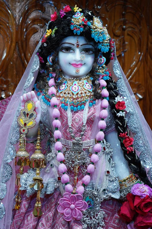 A statue of krishna in a pink dress