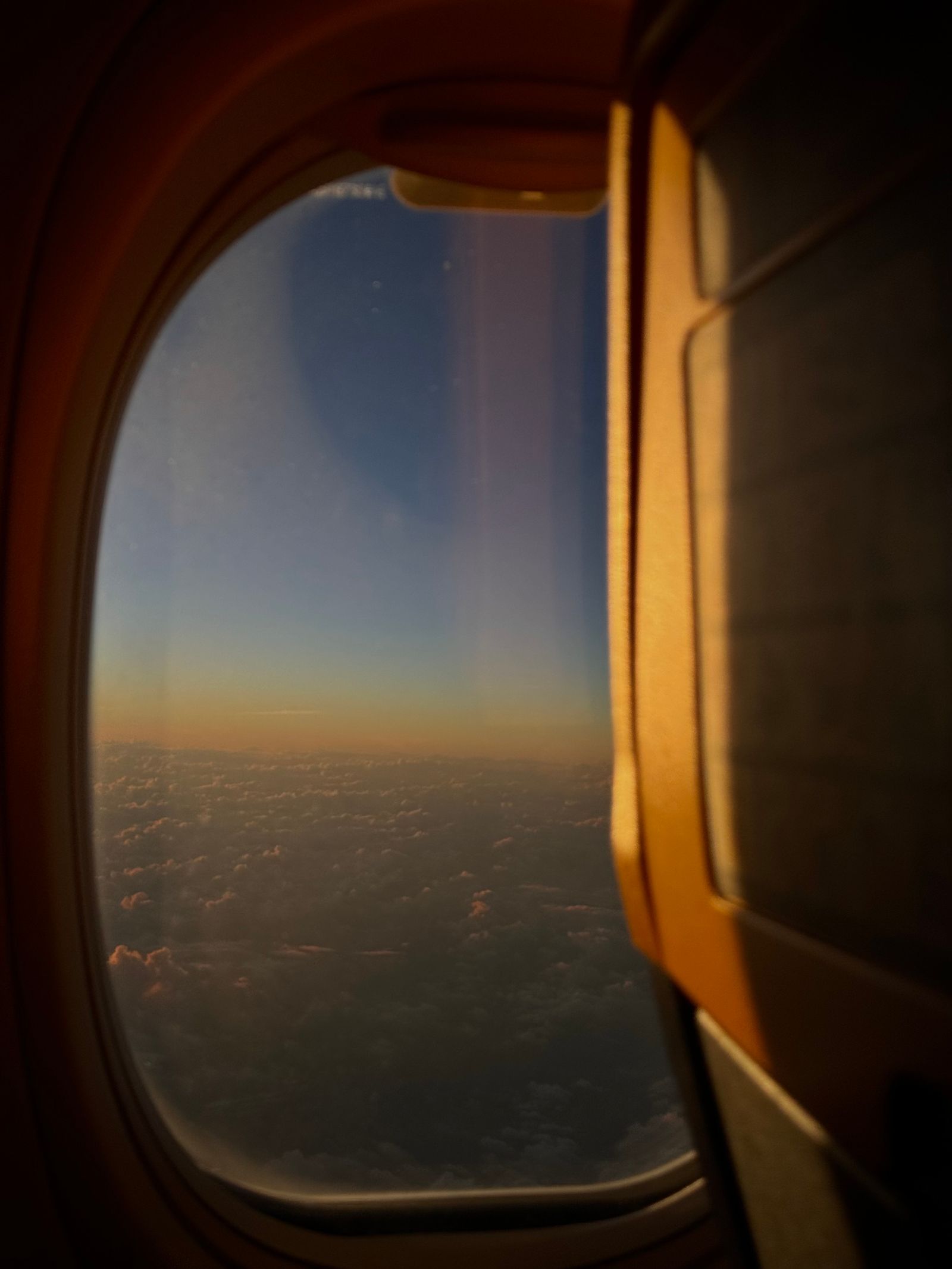 View of a sunset sky and clouds from an airplane window