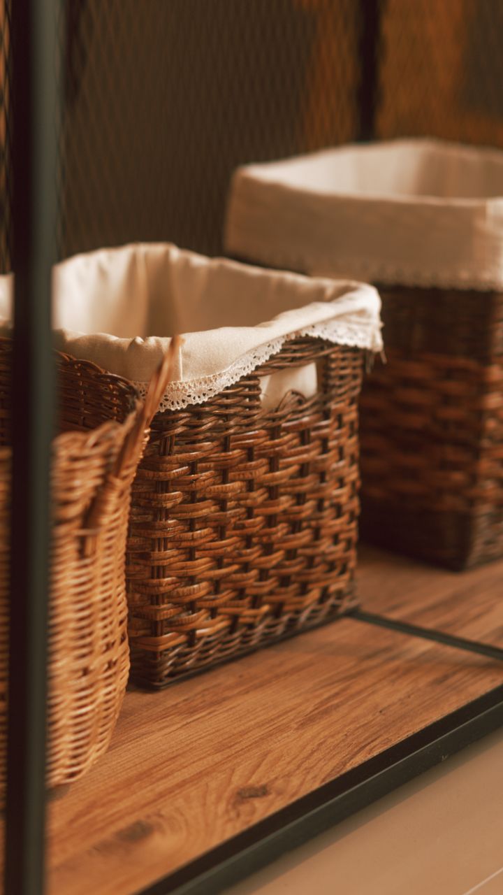 Woven storage bins holding tea bags and coffee pods on a coffee and tea bar shelf