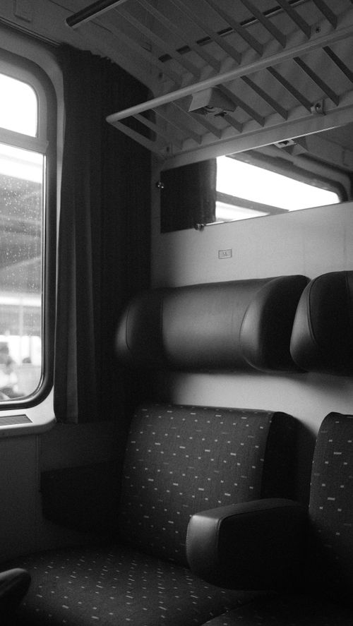Free Elegant black and white shot of a train interior, capturing seats and window view. Stock Photo