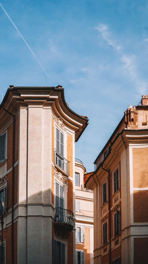 Free A striking view of classic residential facades under a clear blue sky in Rome, Italy. Stock Photo