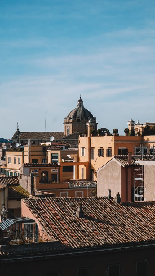 Free Charming cityscape capturing Rome's iconic domes and rustic rooftops under a clear sky. Stock Photo