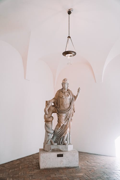 A statue in a room with a light above it