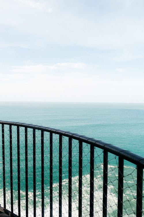 A balcony overlooking the ocean with a railing