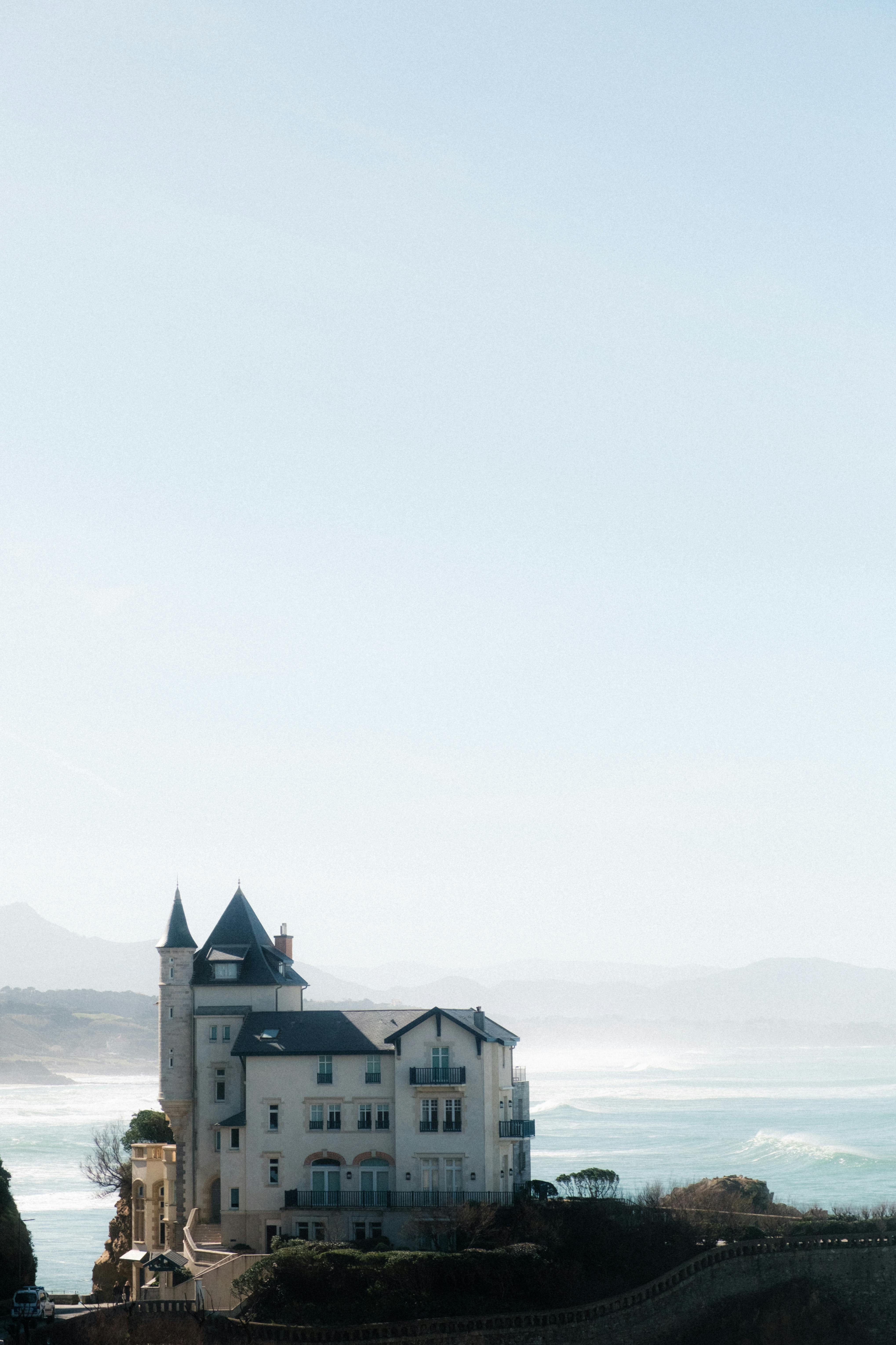 Stunning seaside castle with gothic architecture against a blue sky.