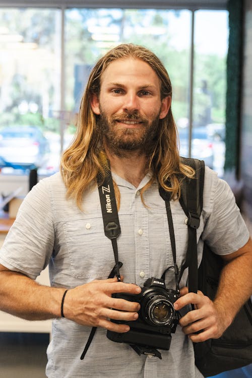 Free A man with long hair holding a camera Stock Photo