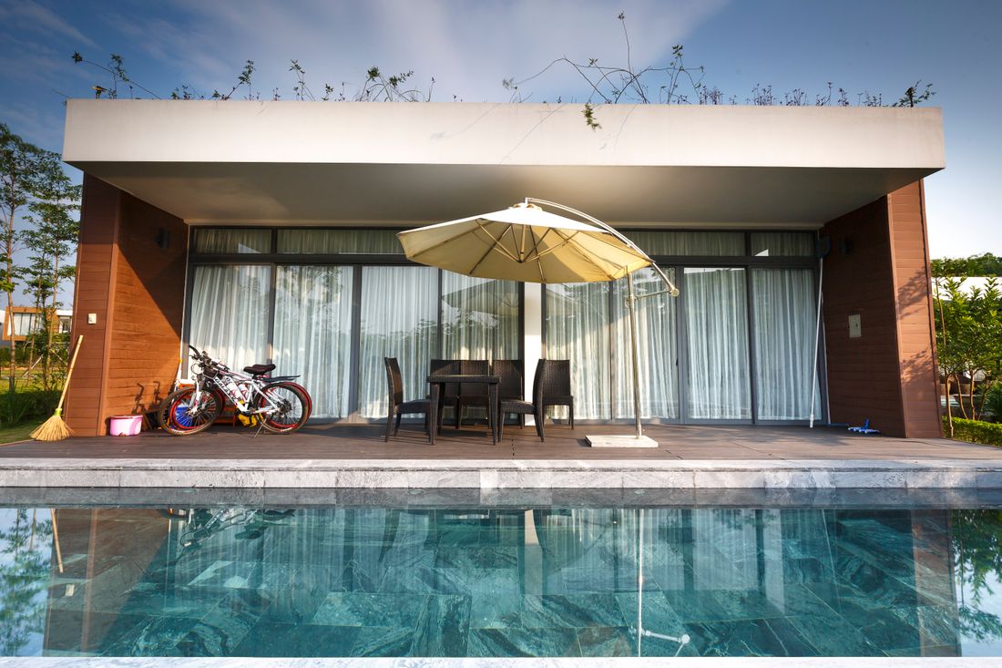 Contemporary outdoor patio with chairs and poolside view