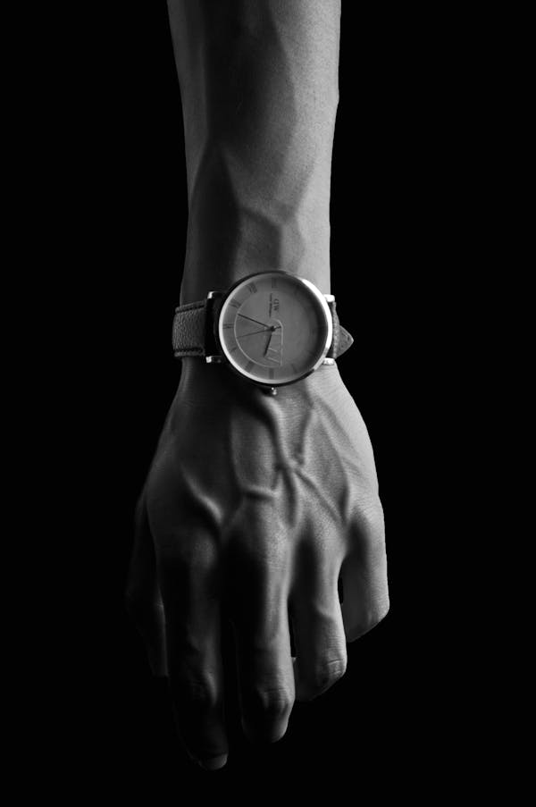 Grayscale Photo of Person Wearing Round Analog Watch