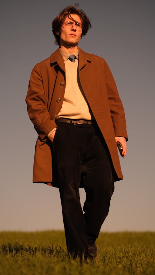 Free A man in a brown coat and pants standing in a field Stock Photo