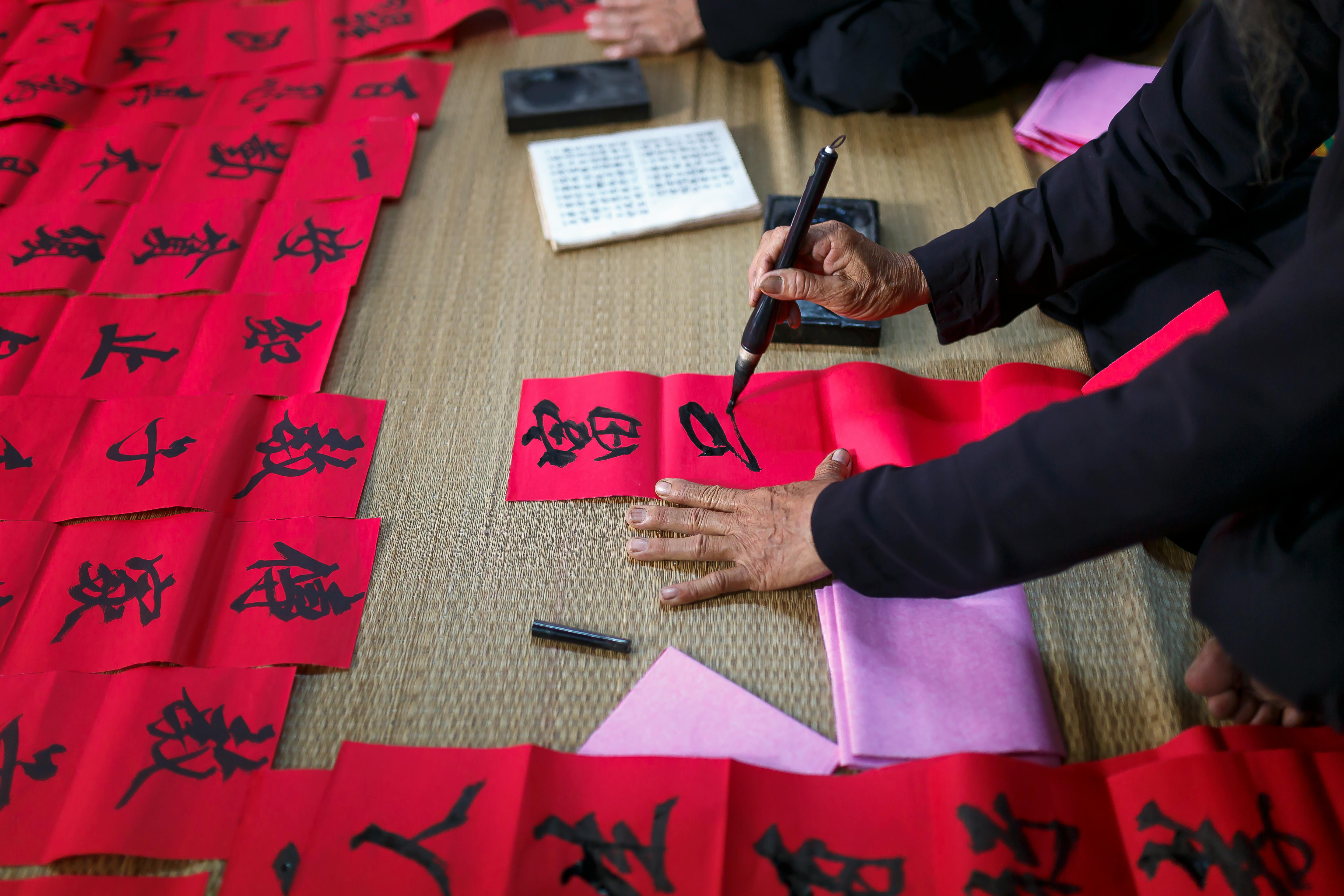 person writing on red paper