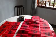 在宁静的室内环境中，用红纸练习中国书法，字体优雅