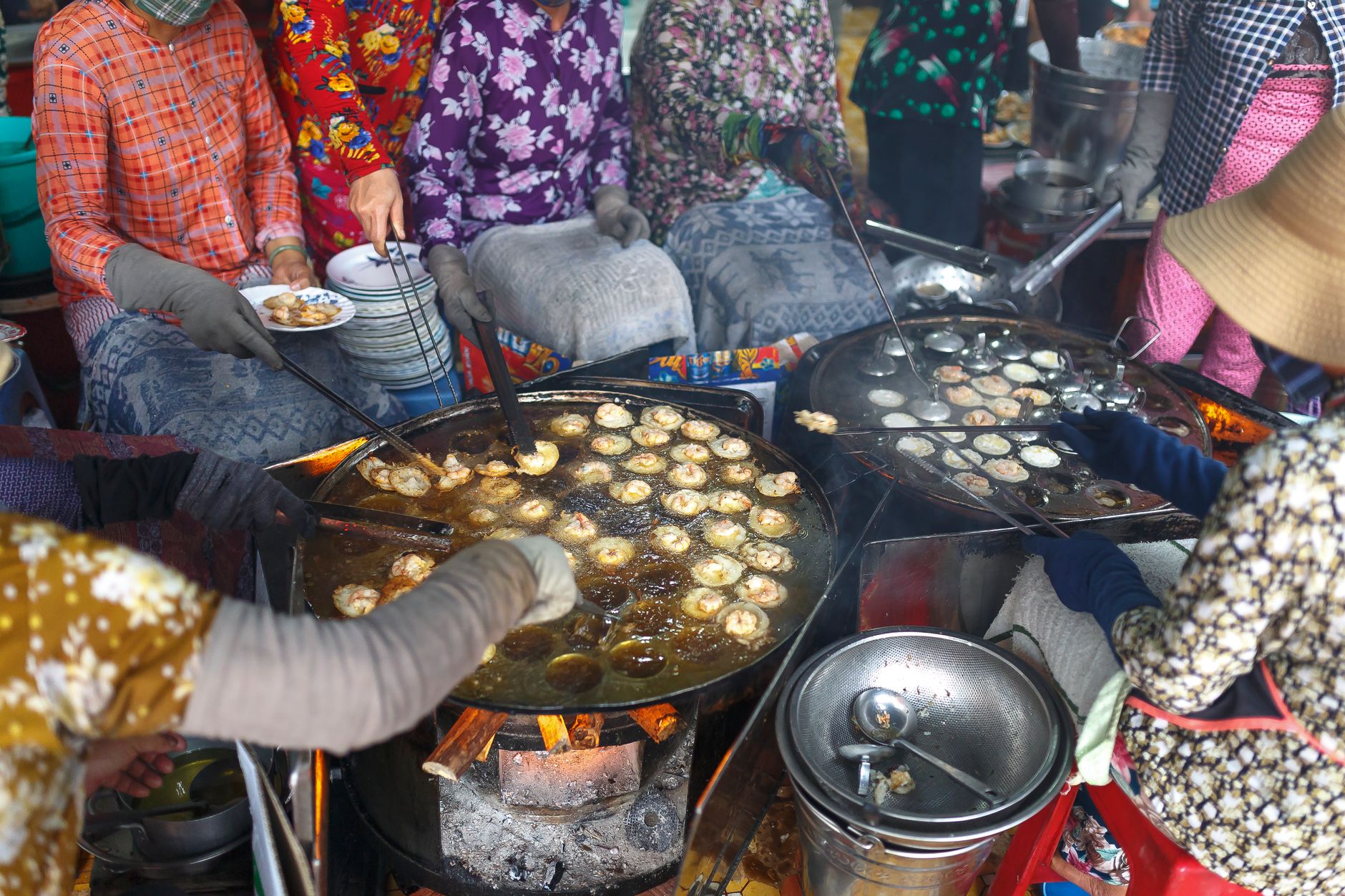 Street vendor frying golden bhature in a large pan at a Delhi food stall